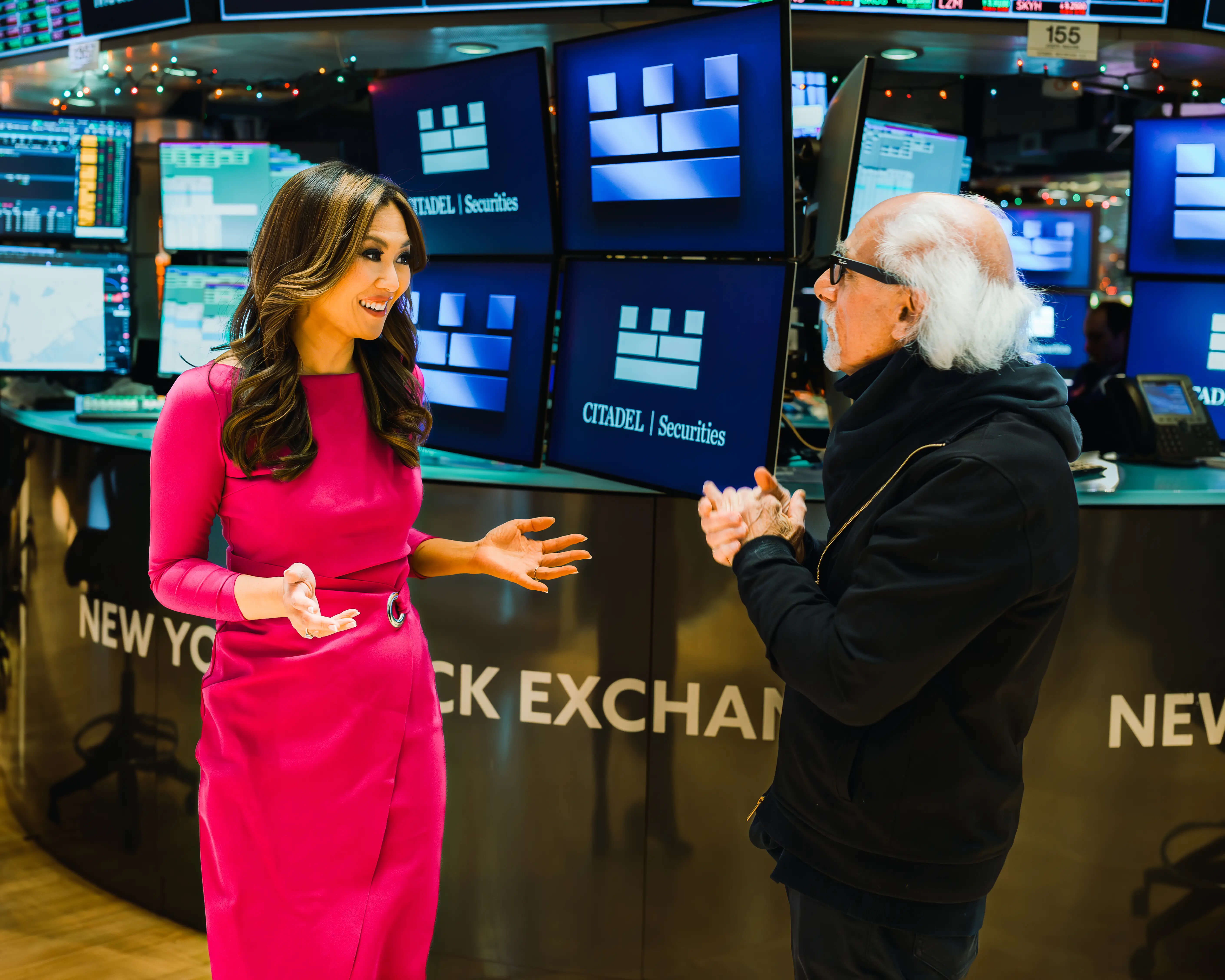 Remy Blaire in conversation with a business executive during an on-camera interview